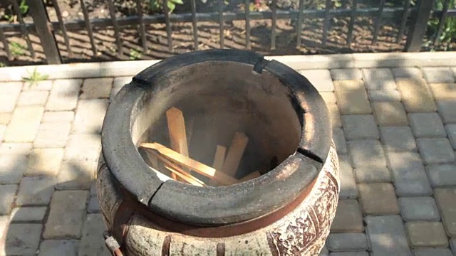 热,加热筒状泥炉。点燃纸张和装载木片