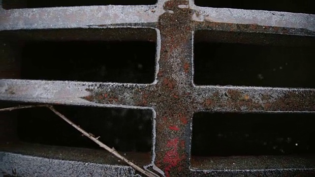 水滴流进有格栅的下水道