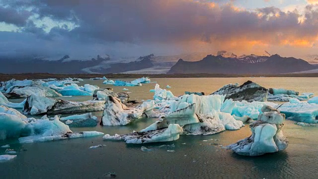 日落时分，冰岛东南部Vatnajkull国家公园附近Jökulsárlón冰川泻湖水域中的冰川。缩小。4 k UHD间隔拍摄。