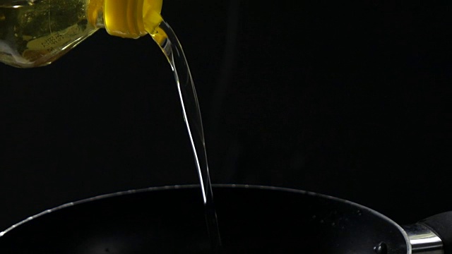 厨师用慢动作将油倒入锅中