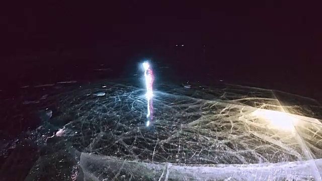 女人是滑冰之夜。女孩在大自然中骑着花样滑冰鞋。一个女人在冰裂缝上骑马。冰上的神奇天使。穿着冰鞋的人们在大自然中享受冬季活动。