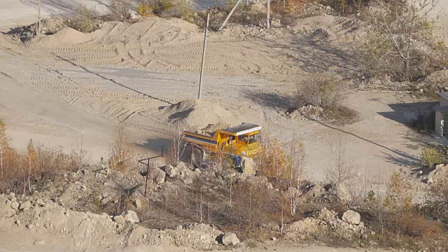 采矿卡车在巨大的露天矿山，重型采矿卡车装载着铁矿石在露天采石场上，俯视