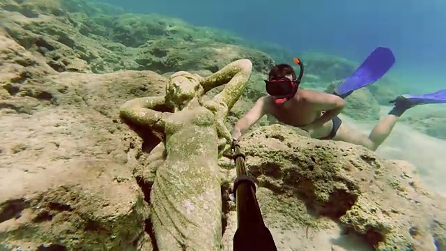年轻人潜水去看海底的雕像