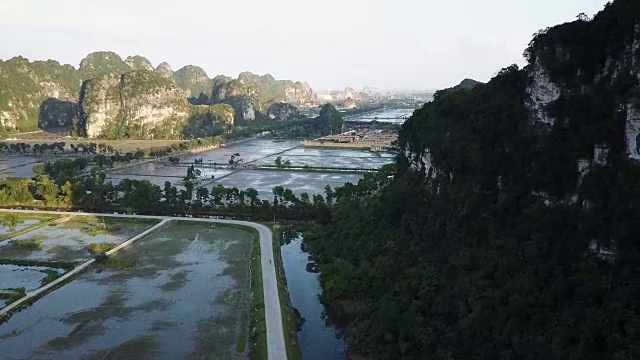 无人机在稻田上空拍摄，遥望远方地平线上的一座城市