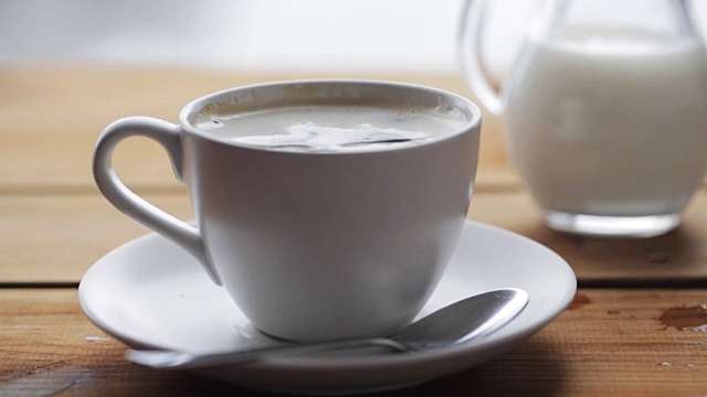 糖掉进了木桌上的咖啡杯里