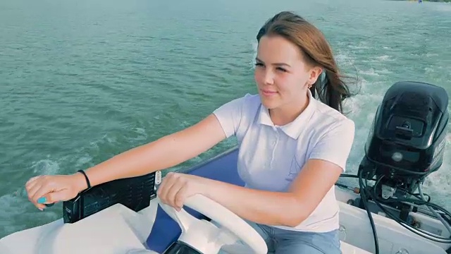暑假,旅游。一位美丽的年轻女孩驾着摩托艇在湖上航行
