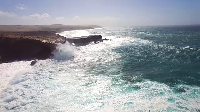 在富埃特文图拉，海浪撞击punta Guadalupe的岩石的鸟瞰图。