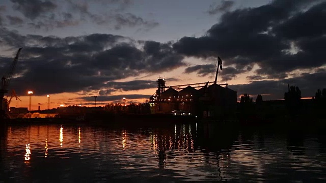 详情图-傍晚海港的大型粮食码头全景。谷物散货在夜间转船。从泊位的大型电梯装载粮食作物上船。选择性聚焦和散景