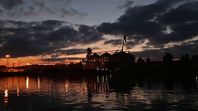 详情图-傍晚海港的大型粮食码头全景。谷物散货在夜间转船。从泊位的大型电梯装载粮食作物上船。选择性聚焦和散景