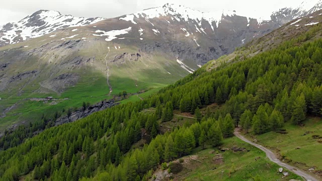 空中:飞越高山峡谷，风景如画的瀑布，雪山山脉和戏剧性的道路