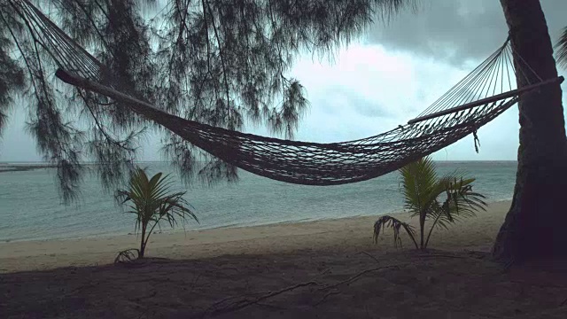 详情图-慢镜头:热带海滩上孤独的吊床在狂风暴雨中摇摆。