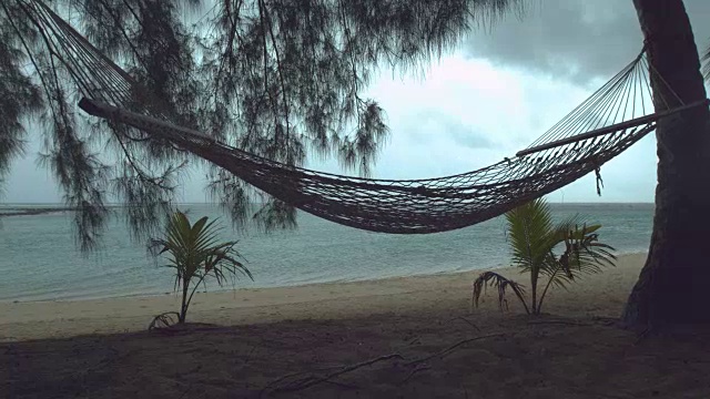 详情图-慢镜头:热带海滩上孤独的吊床在狂风暴雨中摇摆。