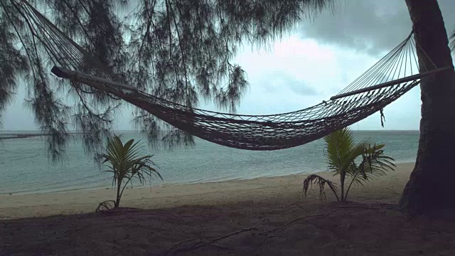 详情图-慢镜头:热带海滩上孤独的吊床在狂风暴雨中摇摆。