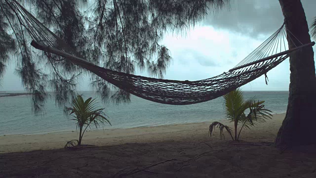 详情图-慢镜头:热带海滩上孤独的吊床在狂风暴雨中摇摆。