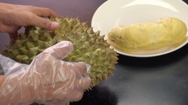 詳情圖-手把去皮的榴蓮放在白色盤子上