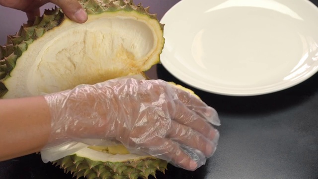 詳情圖-手把去皮的榴蓮放在白色盤子上