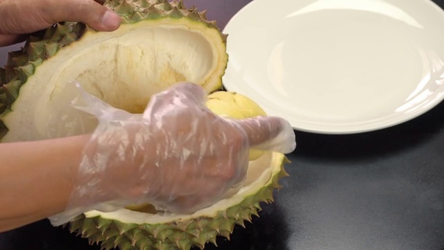 詳情圖-手把去皮的榴蓮放在白色盤子上