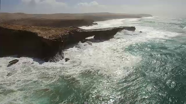 在富埃特文图拉，海浪撞击punta Guadalupe的岩石的鸟瞰图。