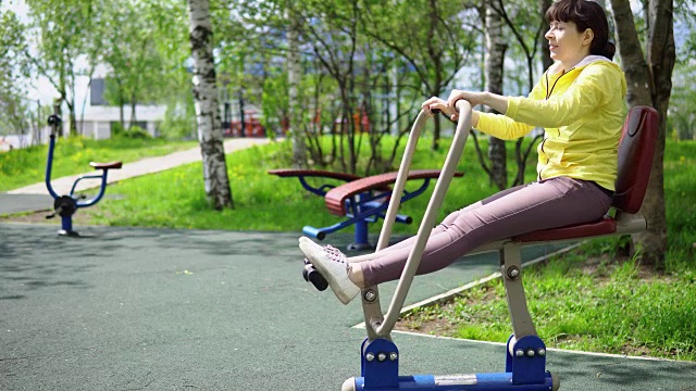 年轻女子在户外的固定模拟器上训练。