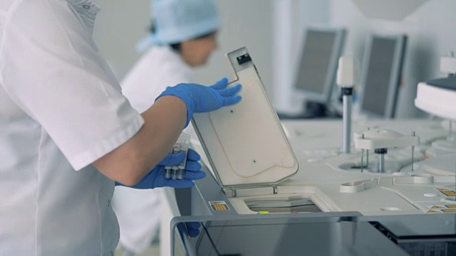 护士在现代化的实验室里用专用机器做了测试后取瓶样本。