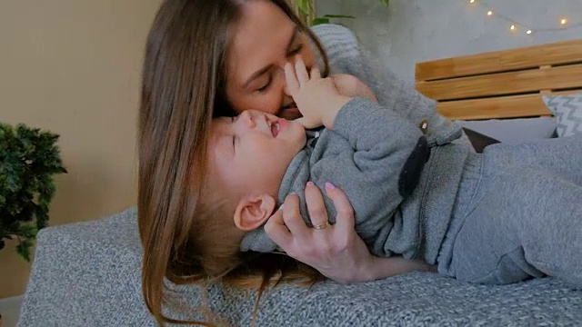 快乐的年轻妈妈和她的宝贝儿子一起玩