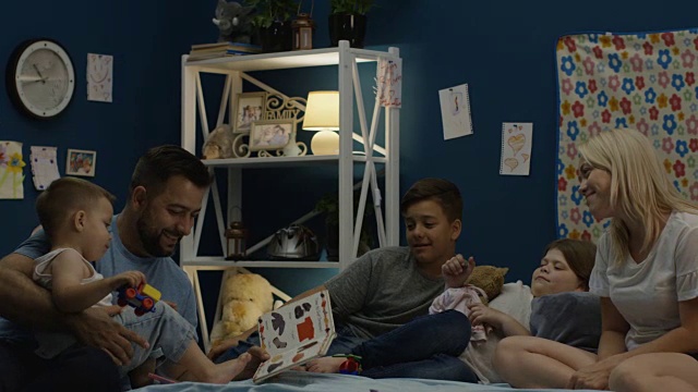 男人在床上给家人讲故事