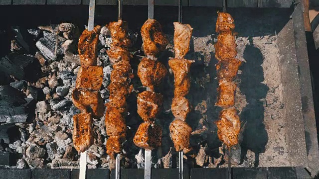 俯视图在自然烧烤上烤的羊肉串。街头食品