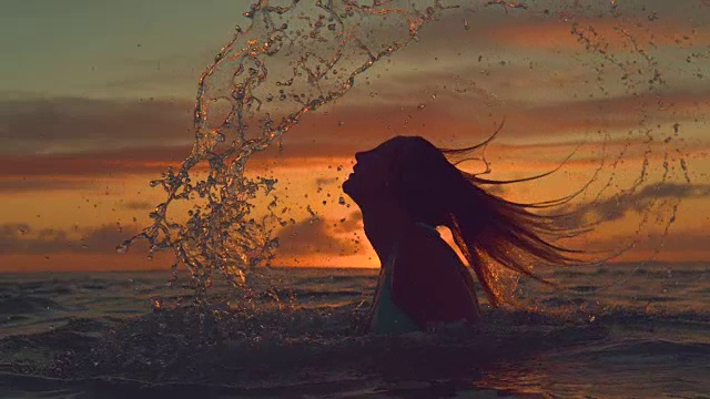 詳情圖-剪影:女孩用她的長發(fā)潑海水在一個壯觀的晚上