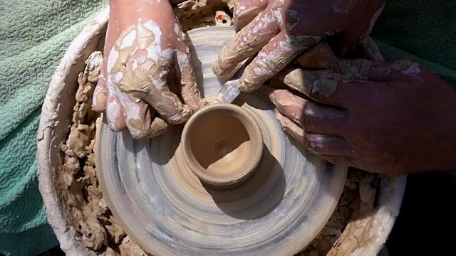 顶视图在波特的手工作与粘土在一个波特的车轮。慢动作