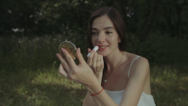 詳情圖-迷人的女人在公園里涂口紅