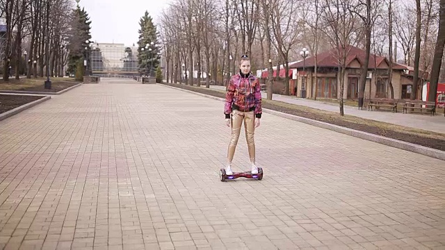 悲伤的女孩在空旷的公园里骑着电子滑板车