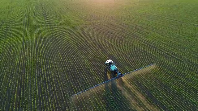 詳情圖-4K無人機(jī)拍攝的畫面。在夕陽下的大豆田上跟著拖拉機(jī)噴霧器