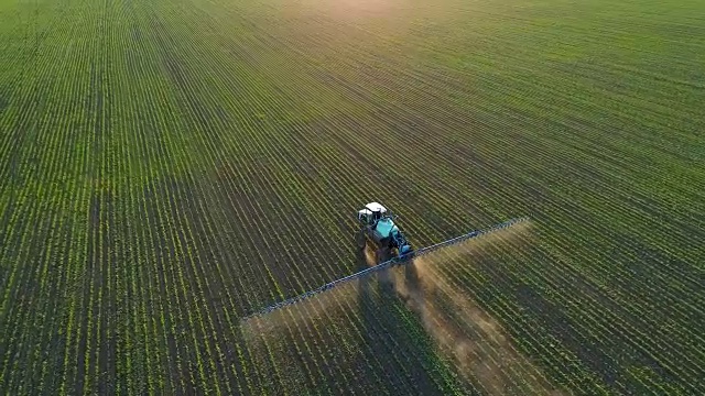 詳情圖-4K無人機(jī)拍攝的畫面。在夕陽下的大豆田上跟著拖拉機(jī)噴霧器