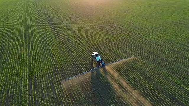 詳情圖-4K無人機(jī)拍攝的畫面。在夕陽下的大豆田上跟著拖拉機(jī)噴霧器