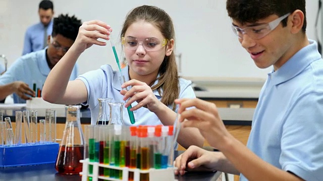 自信的STEM学校学生在做化学实验