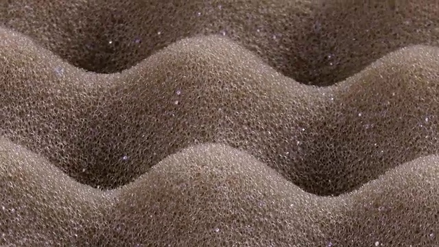 令人惊叹的凹凸不平的聚氨酯泡沫表面多孔的纹理，顺时针旋转接近。