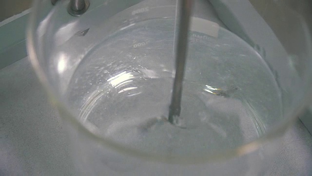 用药物搅拌器在玻璃杯中混合粘性液体的过程