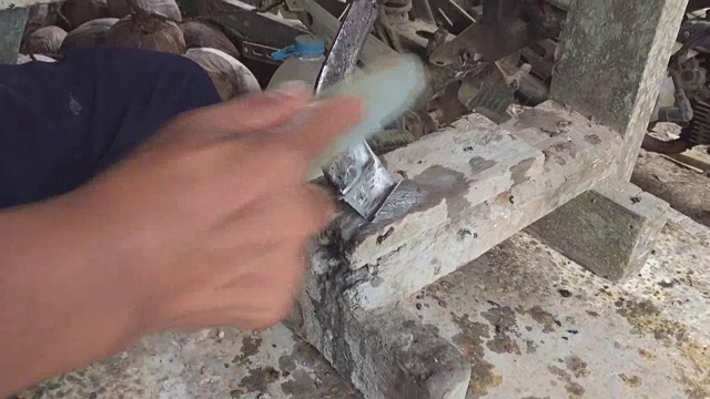 用磨刀石磨橡胶刀的人的手