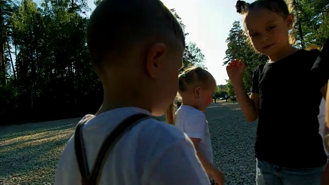 在夏日阳光明媚的日子里，青少年和儿童队伍相互握手致意