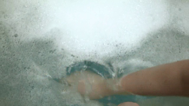 详情图-一个白人小男孩在他的浴缸里玩耍和清洁，而他的妈妈用一个玩具喷射他
