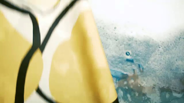 一个白人小男孩在他的浴缸里玩耍和清洁，而他的妈妈用一个玩具喷射他