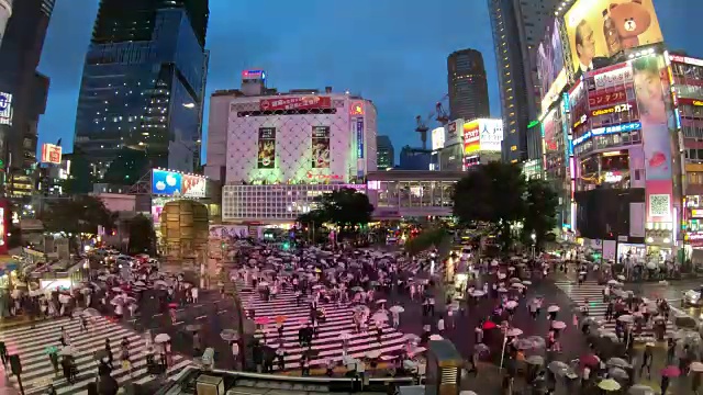 日本东京涩谷，人们撑着雨伞穿过著名的对角线十字路口的4K延时视频