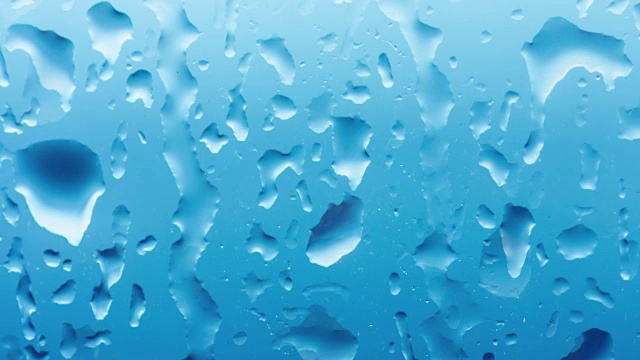 时间流逝，雨滴落在窗玻璃上。近水纹理。循环的电影
