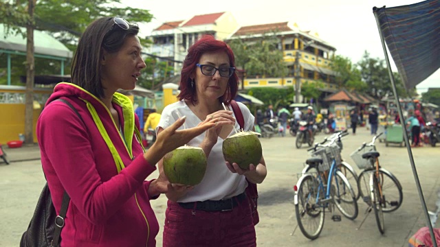 女人在街上喝椰子做的牛奶