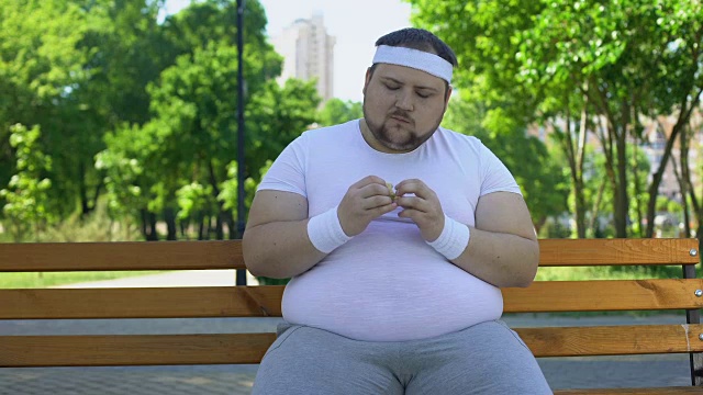 喜欢在公园吃汉堡的胖子，对垃圾食品上瘾，不健康的生活方式