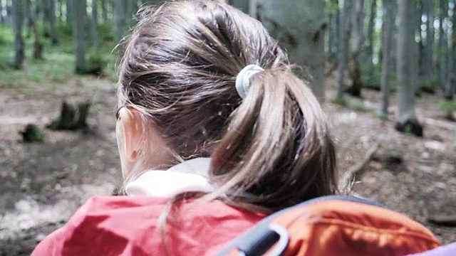一位年轻的女游客走在山间小路上