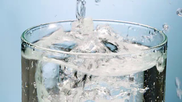 冰块和柠檬片落入水杯